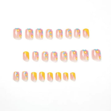 Bright yellow French press-on nails with dainty floral accents.