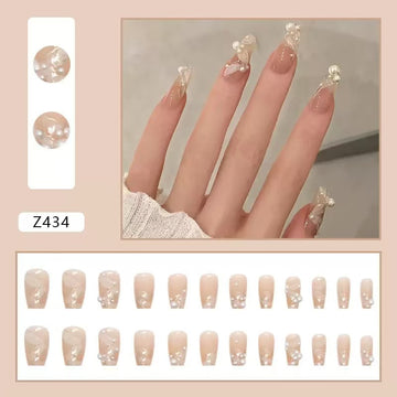 Nude stiletto nails with pearl and glitter decor