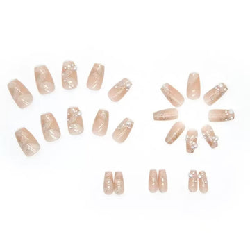 Nude stiletto nails with pearl and glitter decor