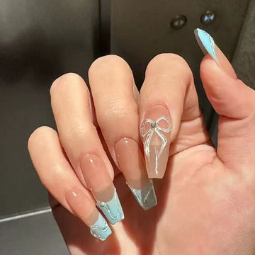 Nude stiletto nails with blue accents and glitter